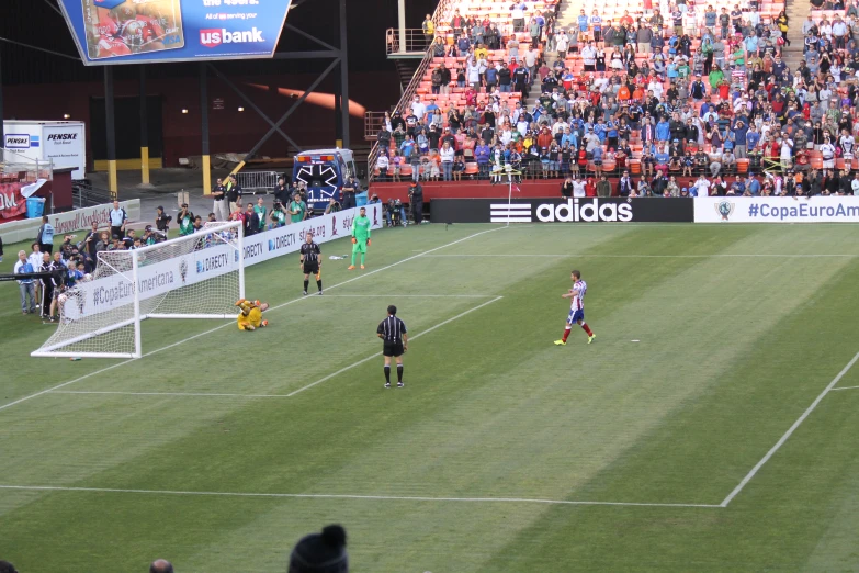 players in uniform playing a soccer game in front of an empty crowd