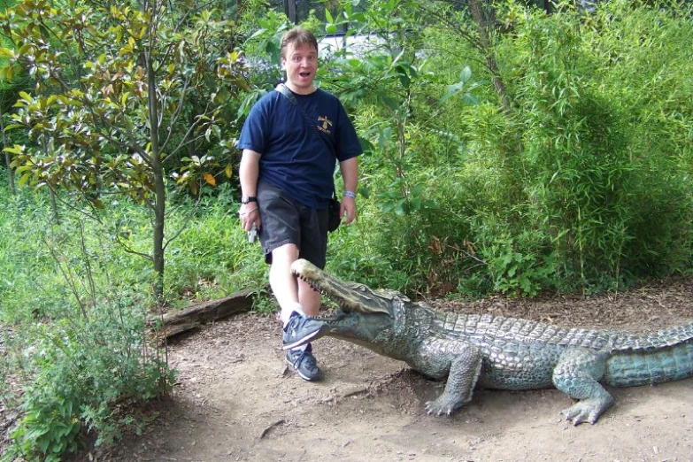 the man is holding onto the crocodile that was on the ground