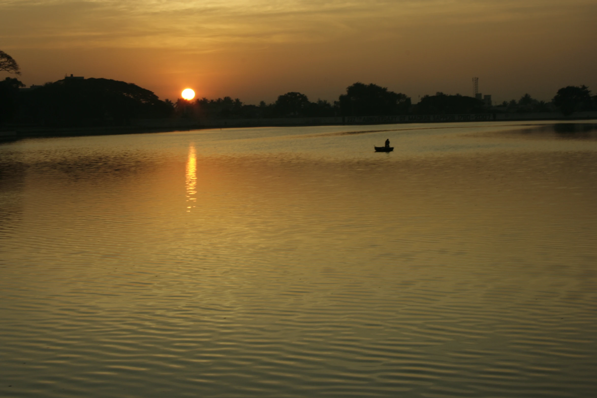 a man in a rowboat paddling on a lake