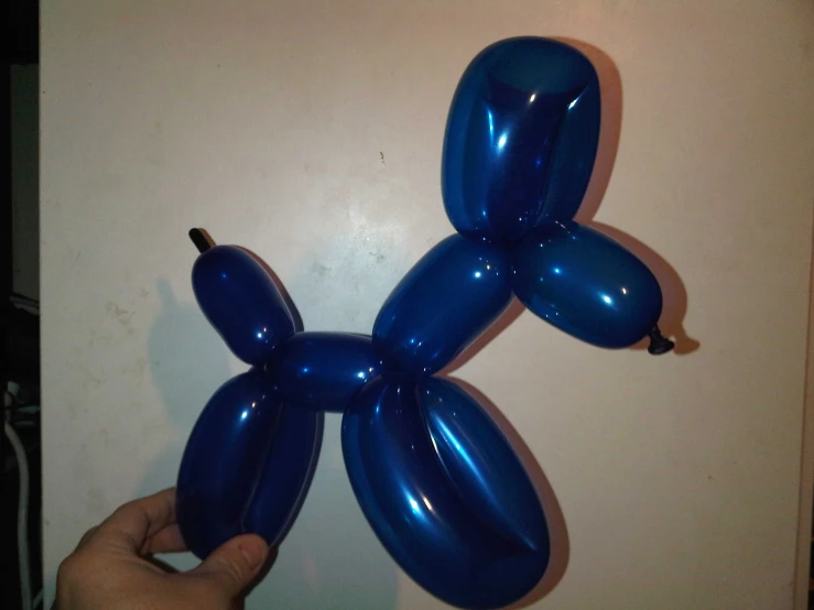 a balloon dog sitting on a wall in the room