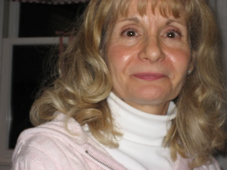 a woman in pink sweater looking into camera
