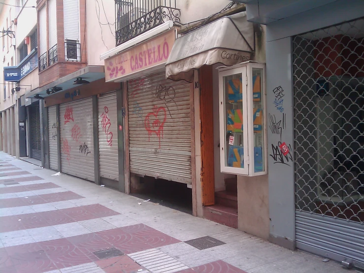 an empty street lined with closed doors and windows