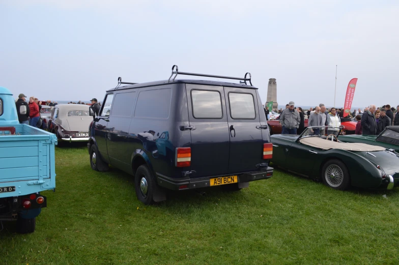 a black and green vehicle and two other vehicles in a field