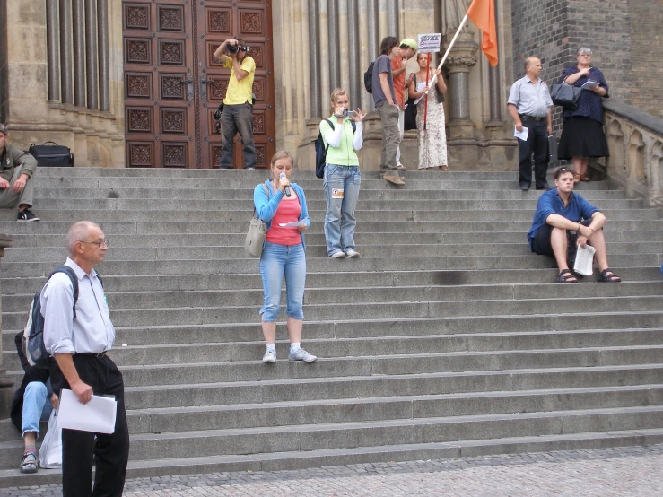 several people taking pictures on some concrete steps