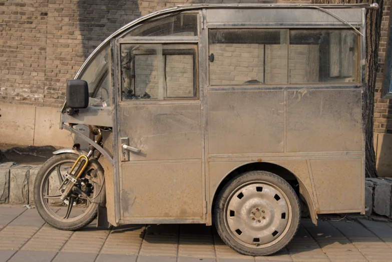 a small metallic van is parked on the side of the street