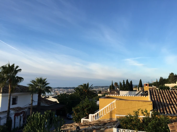 buildings with trees, bushes, and a clear blue sky