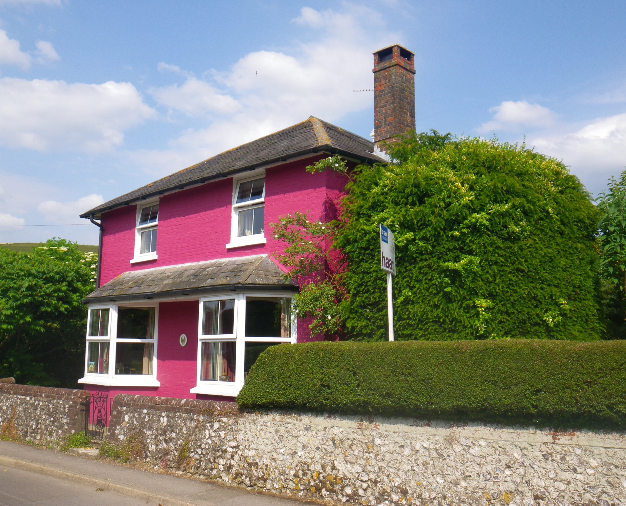 a large house with pink walls and white trim