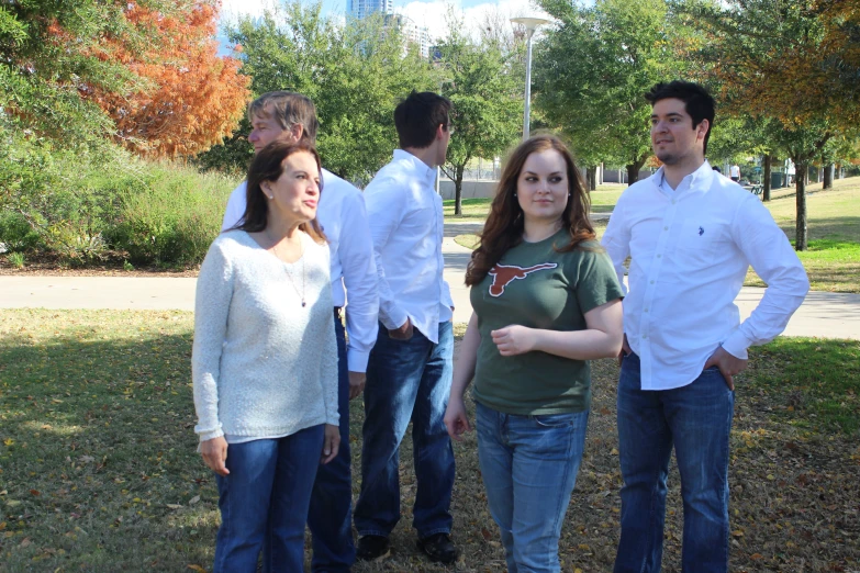 four people stand together while the man has his hands in his pockets