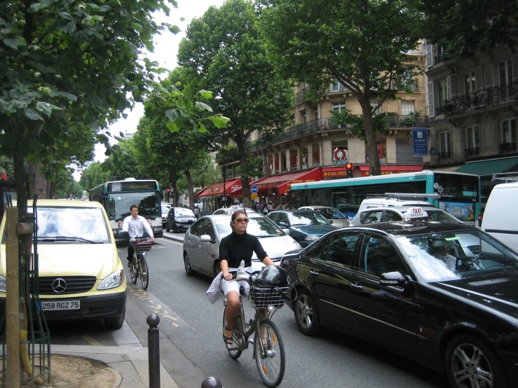 a city street with cars, people and a bicyclist