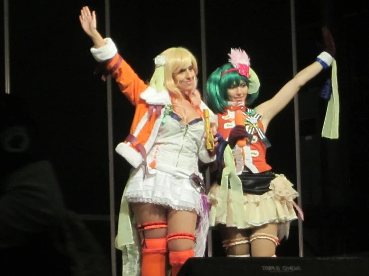 a couple of women wearing short white and orange outfits