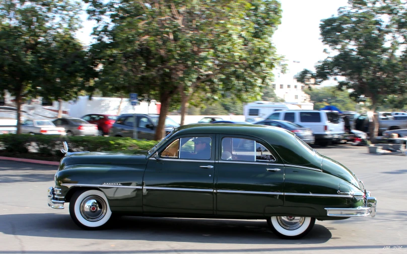 the old car is parked in the lot near other cars