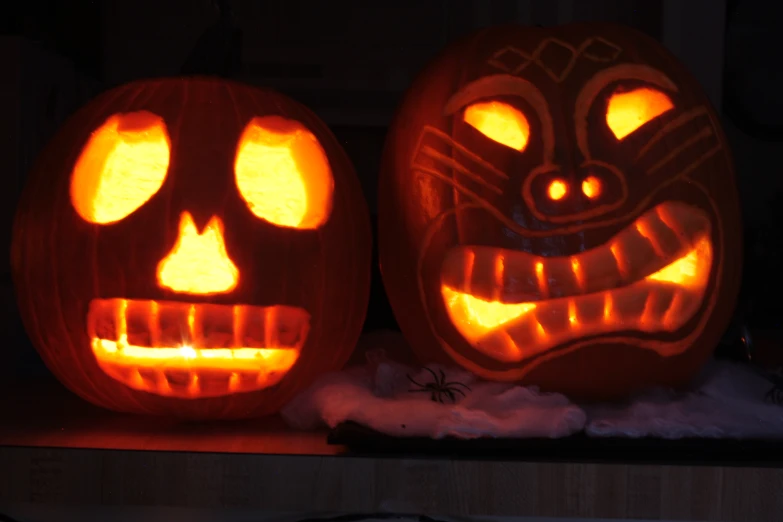 two pumpkins with carved faces that appear to be carved