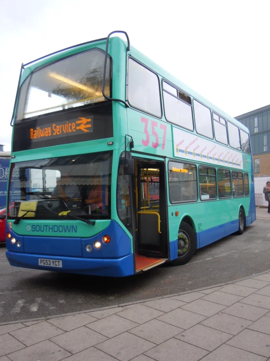 a blue double decker bus is parked near other busses