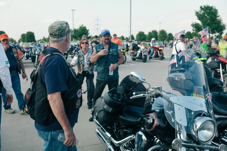 a group of men standing around motor bikes