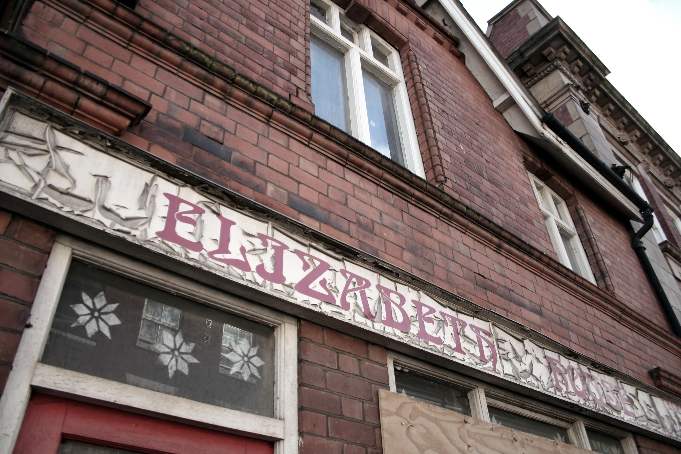 the facade of an old brick building with graffiti on it