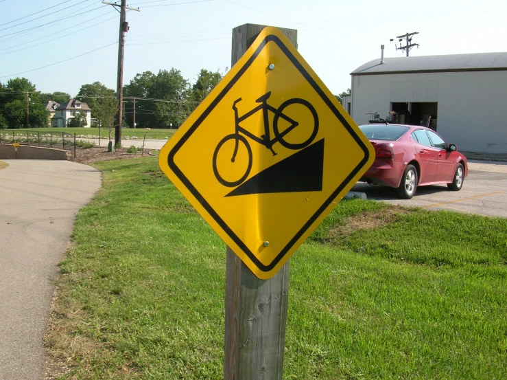 a traffic sign is posted near a path in the grass