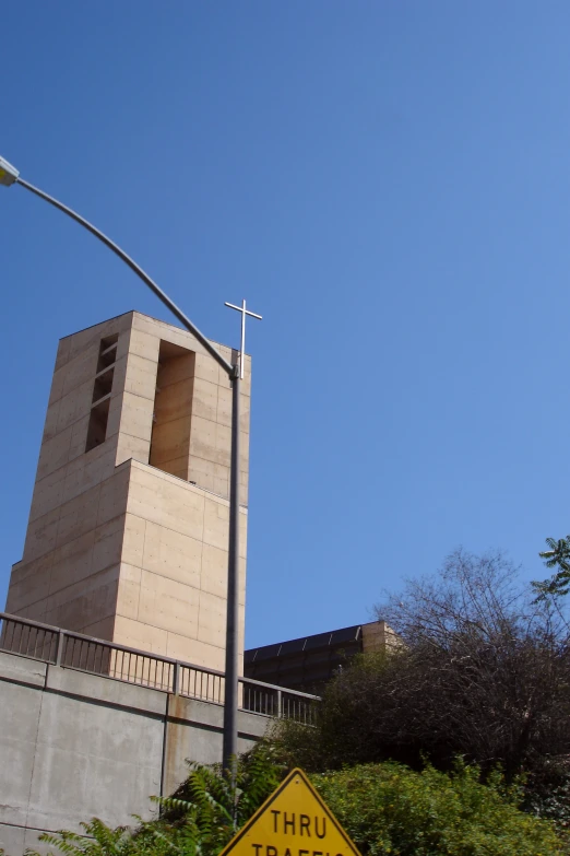 the yellow street sign is below a tall building