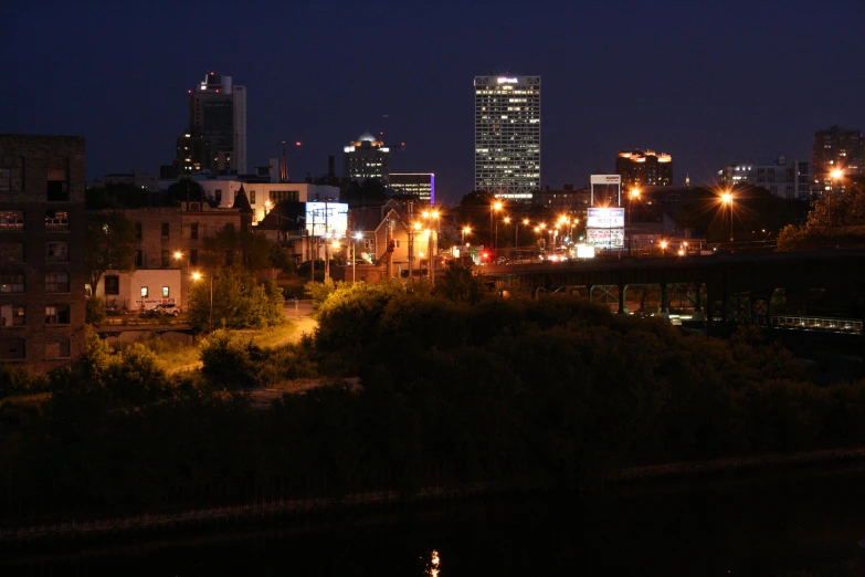 the city lights shine on the buildings along the waterway