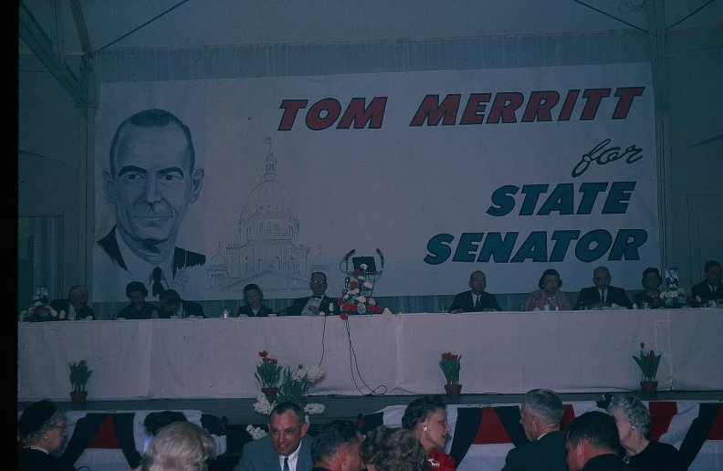 a crowd watching politician speak at podium