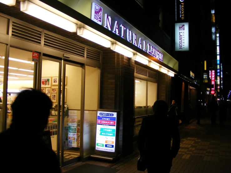 pedestrians walking along side a city street at night