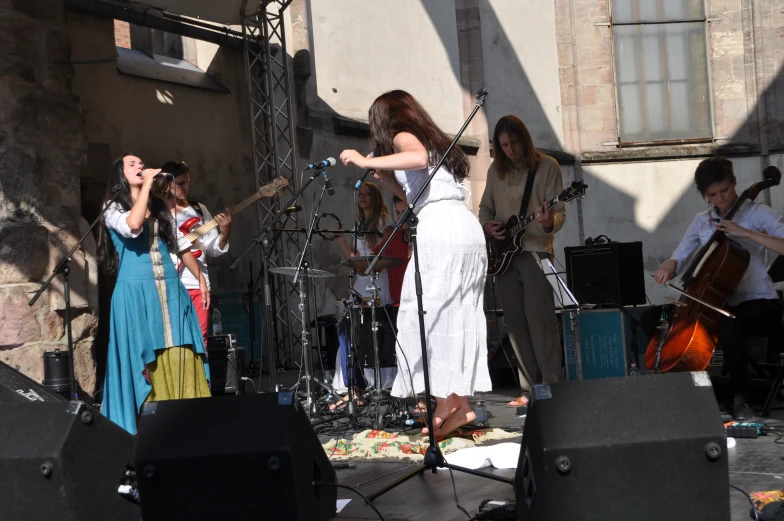 the woman is playing music while others are dancing