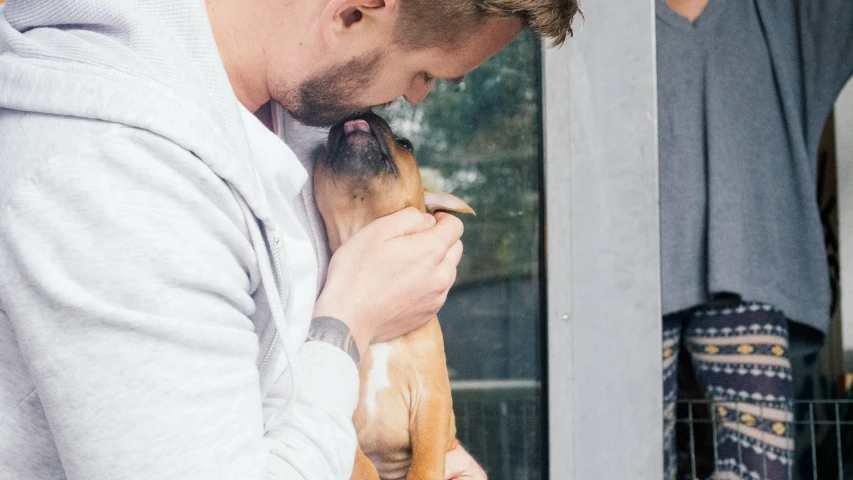 a man holding a brown dog in his lap