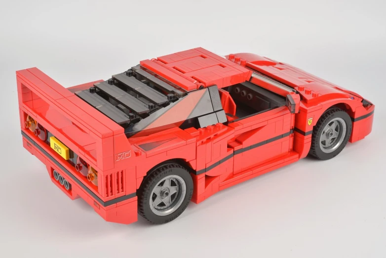 a red lego car on display against a white background