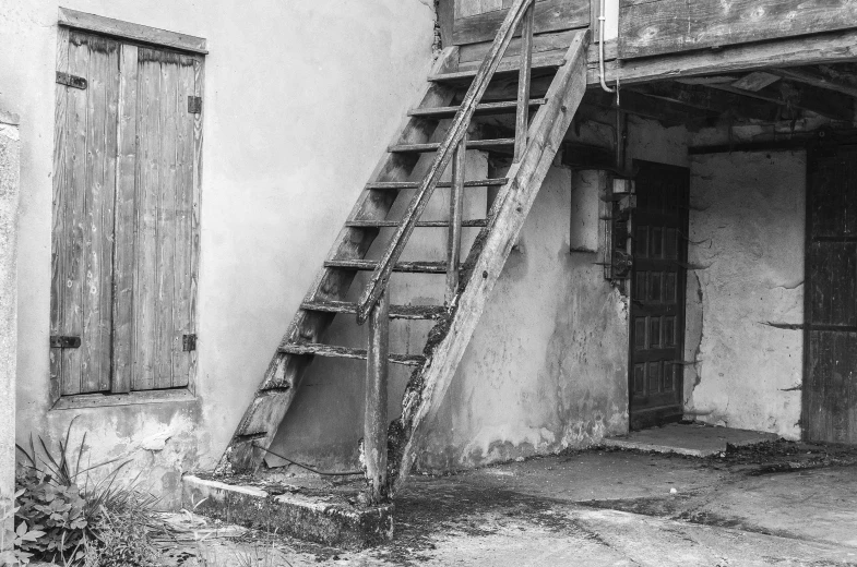 black and white pograph of an old house with an old fire escape