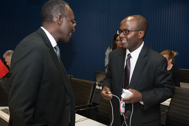 two men in suits and tie talk together