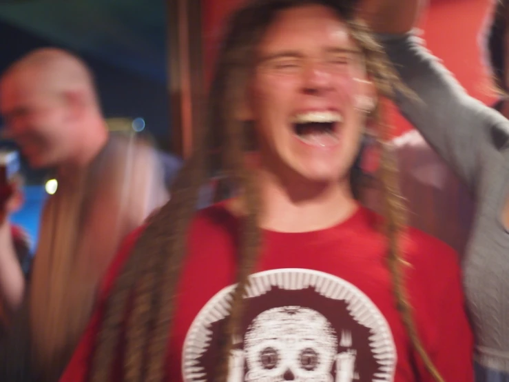 a woman with dreadlocks wearing a red shirt laughing