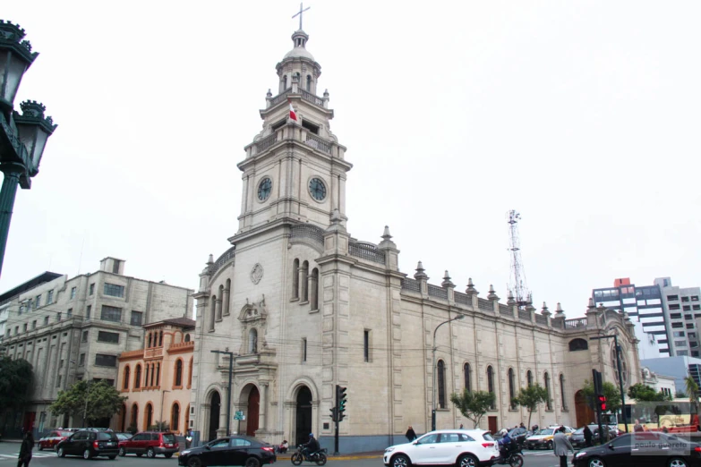 a clock tower with cars passing in front of it