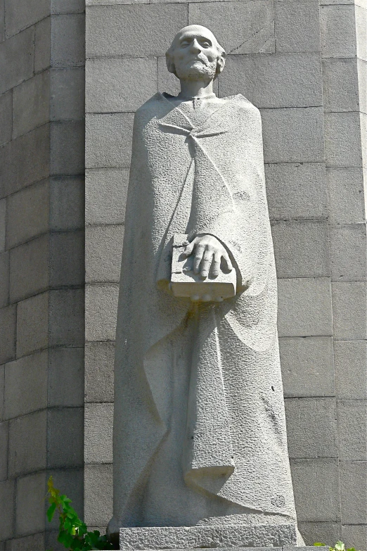 a statue of a woman in a nun outfit standing next to a building