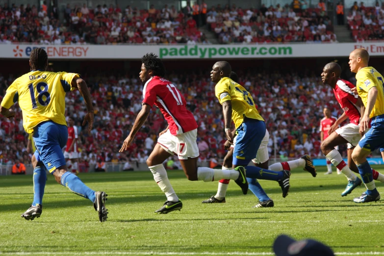 players from two soccer teams playing a game in front of large fans