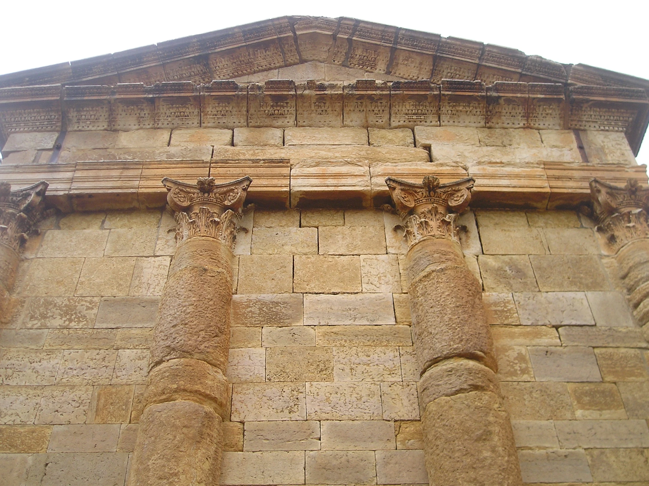 a stone building with four ancient style pillars