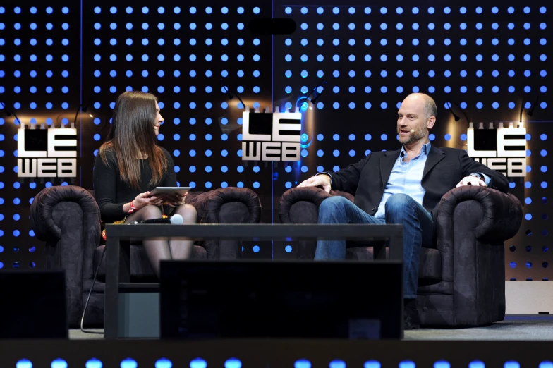 two people sitting in chairs next to each other on a television show