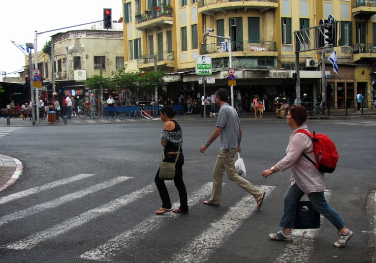 people crossing the road on a crosswalk at a intersection