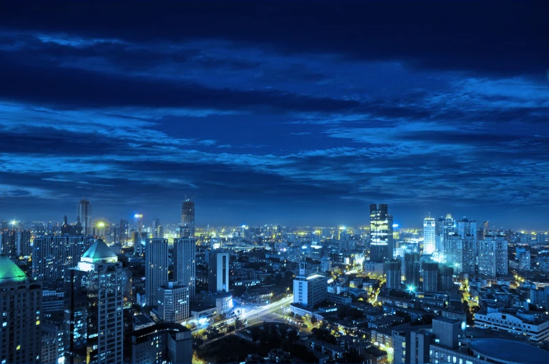 a night view of the city with large buildings and many lights