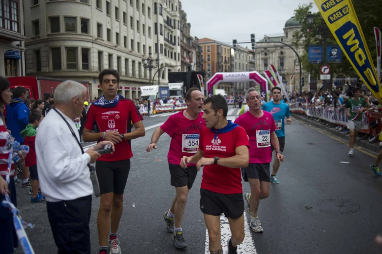 a group of men running down the street in a marathon