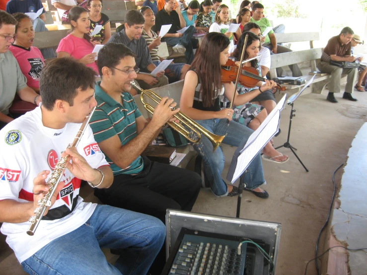 several musicians sitting in a bench with instruments
