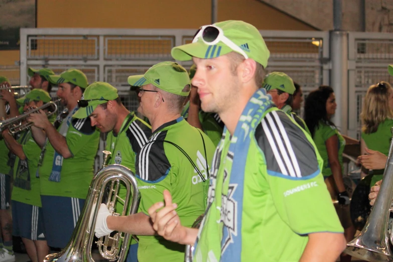 a group of men in green jerseys play music on instruments