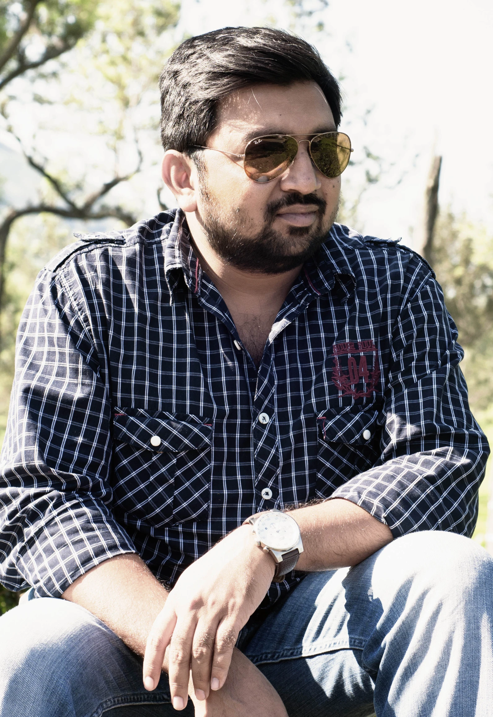 a man sitting down with a watch on his wrist