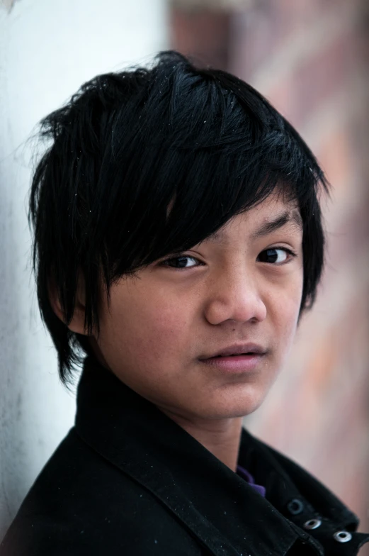 a young man wearing a black shirt and looking into the camera