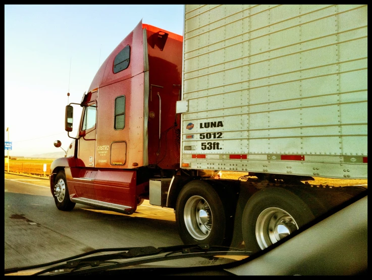 a red and white semi truck driving down the highway