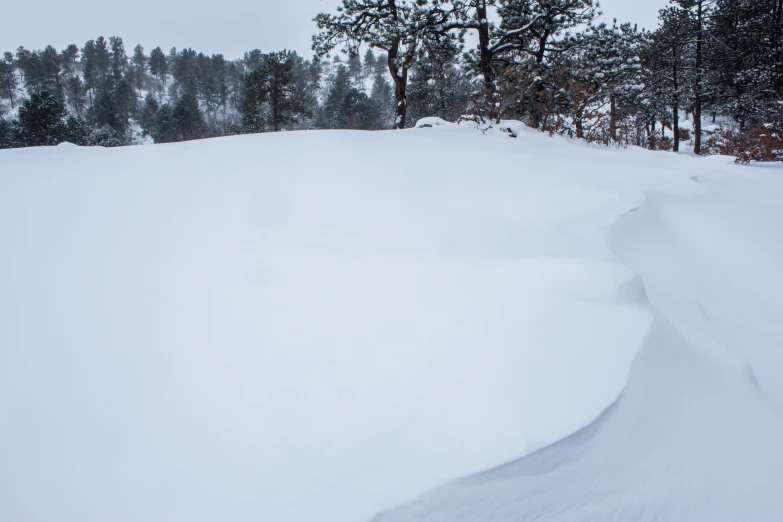 a snowboarder is going down a very snowy slope