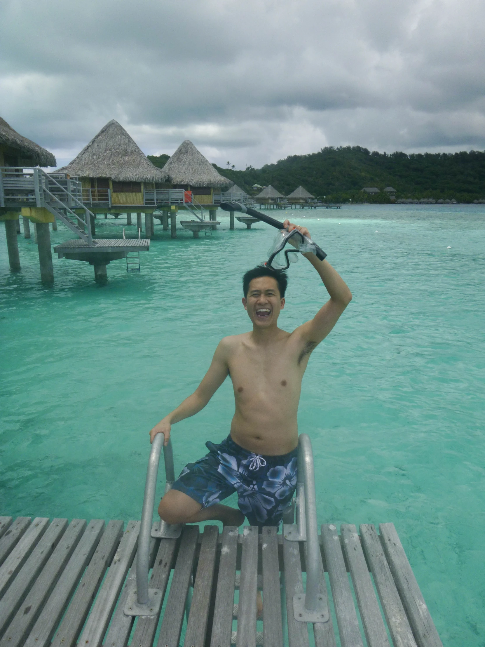 a man sitting on the dock with a racket in his hand