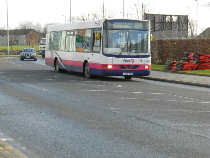 a bus drives down a city street as cars pass