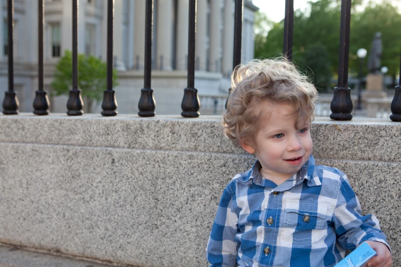 the little boy is wearing a blue checkered shirt