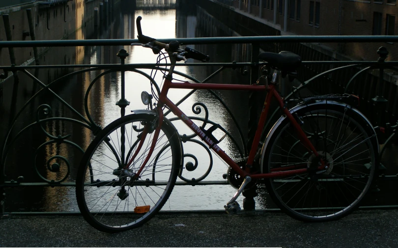 a red bike that is sitting on a rail