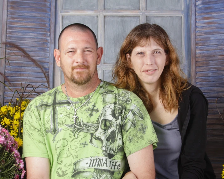 the couple is posing for a po in front of flowers