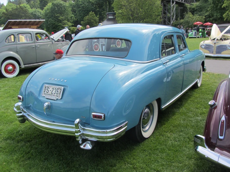 a line up of vintage cars are on display at an outdoor car show